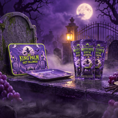 Witches Brew Kit: Hazy Halloween magnetic lid on a mossy gravestone, the rolling tray, and three Witches Brew Vanilla Grapes pouches in a moonlit cemetery